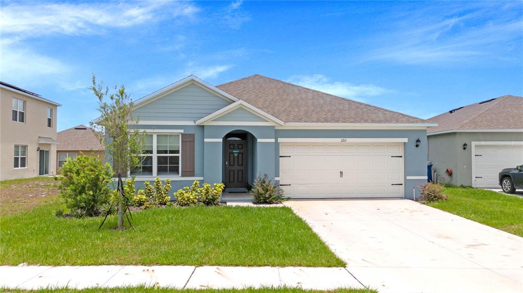 a front view of a house with a yard and garage