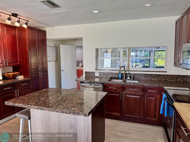 a kitchen with granite countertop sink stove and cabinets