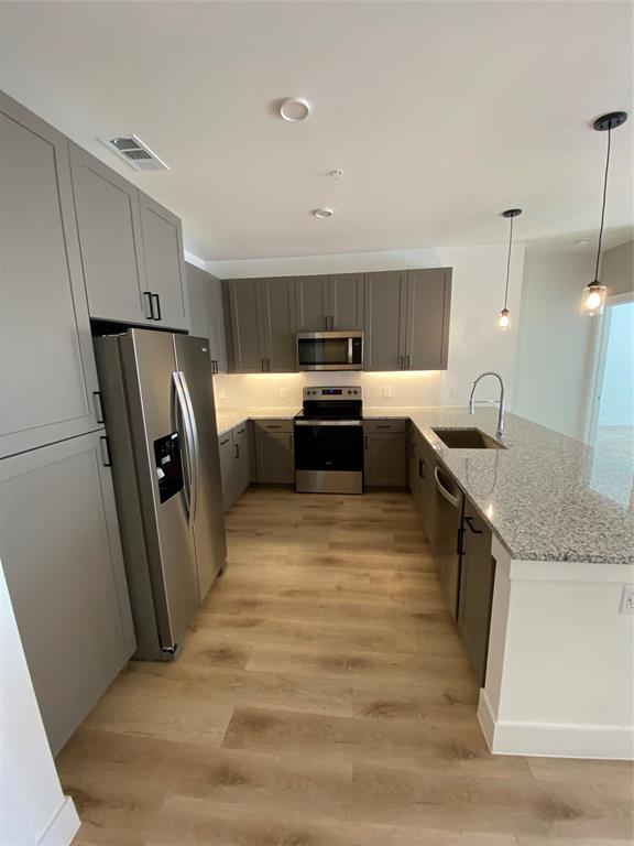 a kitchen with granite countertop a refrigerator stove and sink