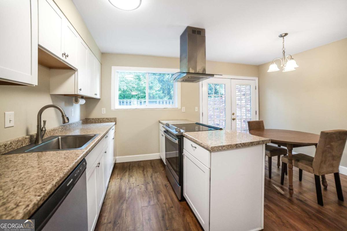 a kitchen with granite countertop a sink and a stove