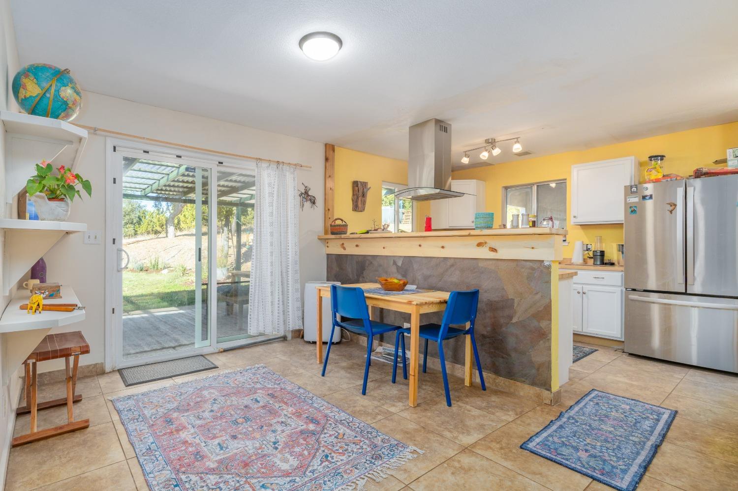 a kitchen with a dining table chairs and refrigerator