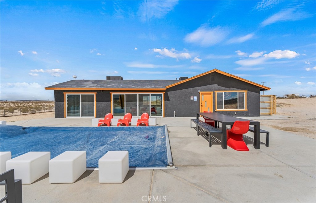 a backyard of a house with table and sofas