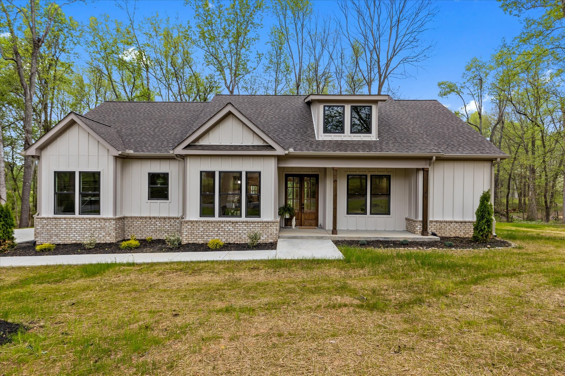 a front view of a house with a garden and yard