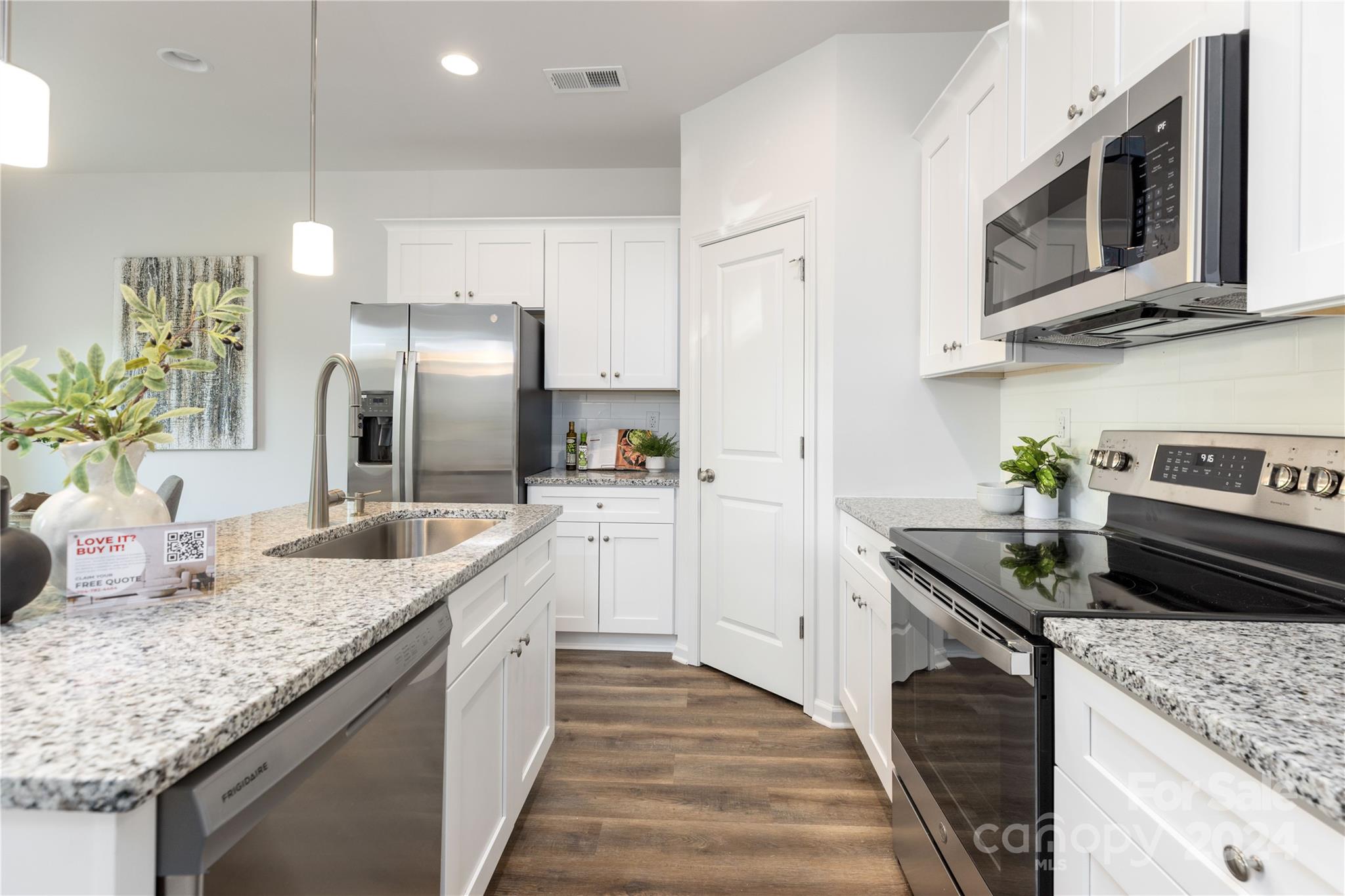 a kitchen with stainless steel appliances granite countertop a sink a stove and a refrigerator