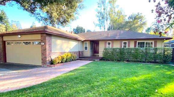 a front view of a house with yard and green space