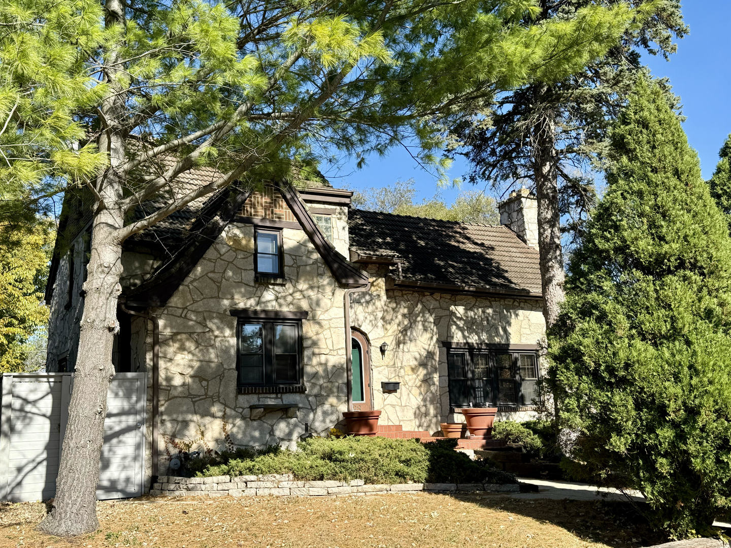 a front view of a house with a tree