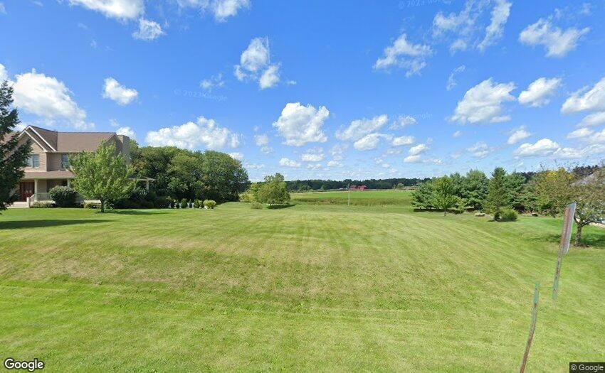 a view of a big yard with swimming pool and green space