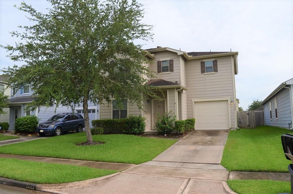 a front view of a house with a garden and plants