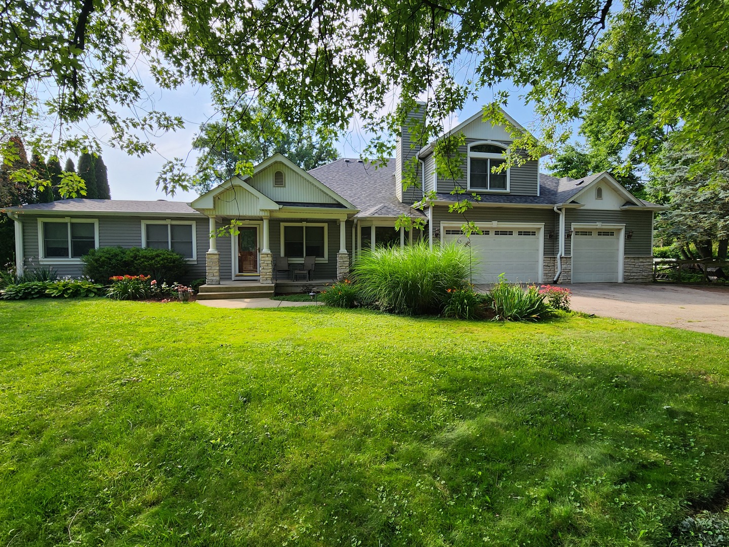 a front view of a house with a garden and trees