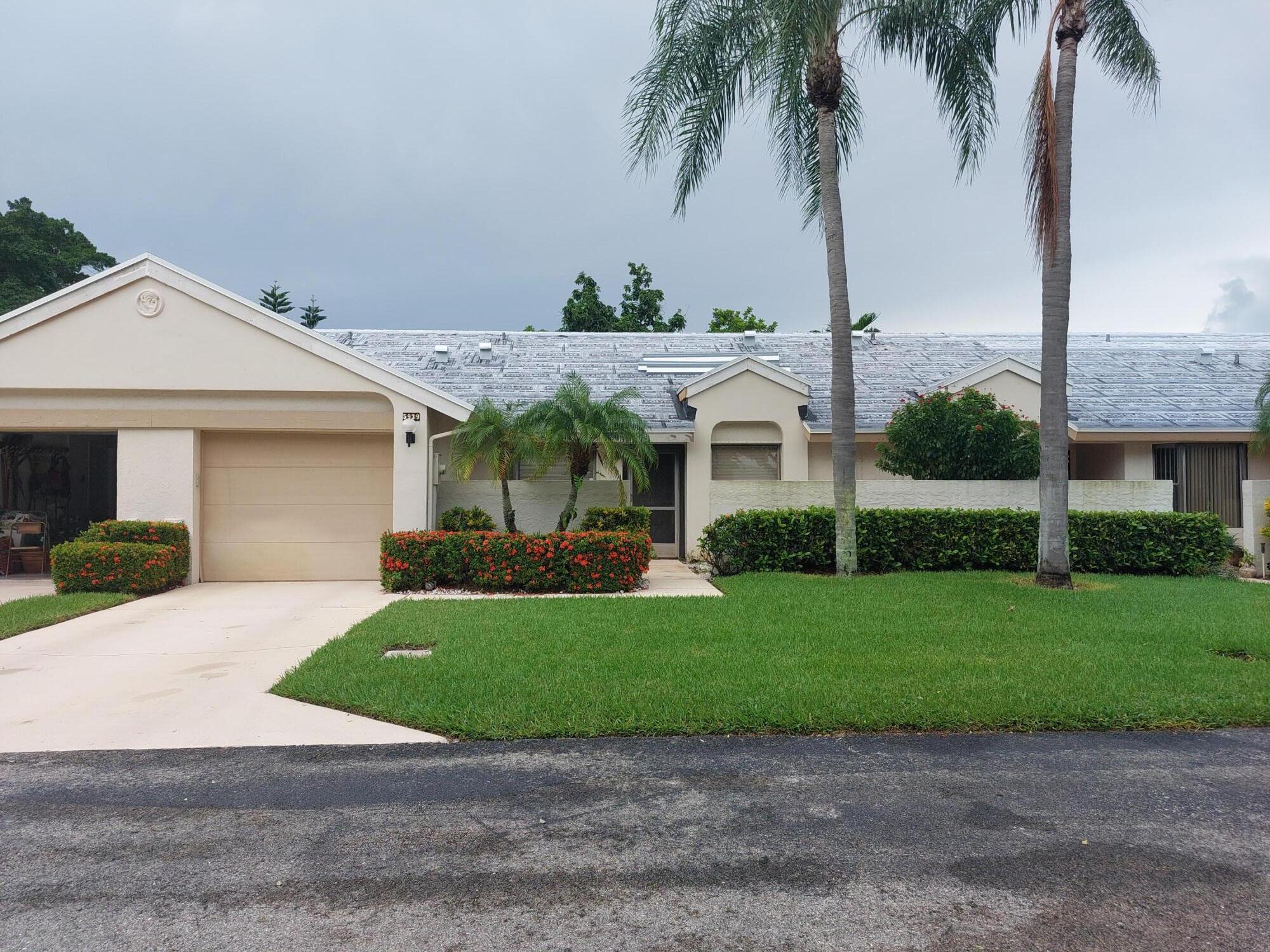 a front view of a house with a garden and yard