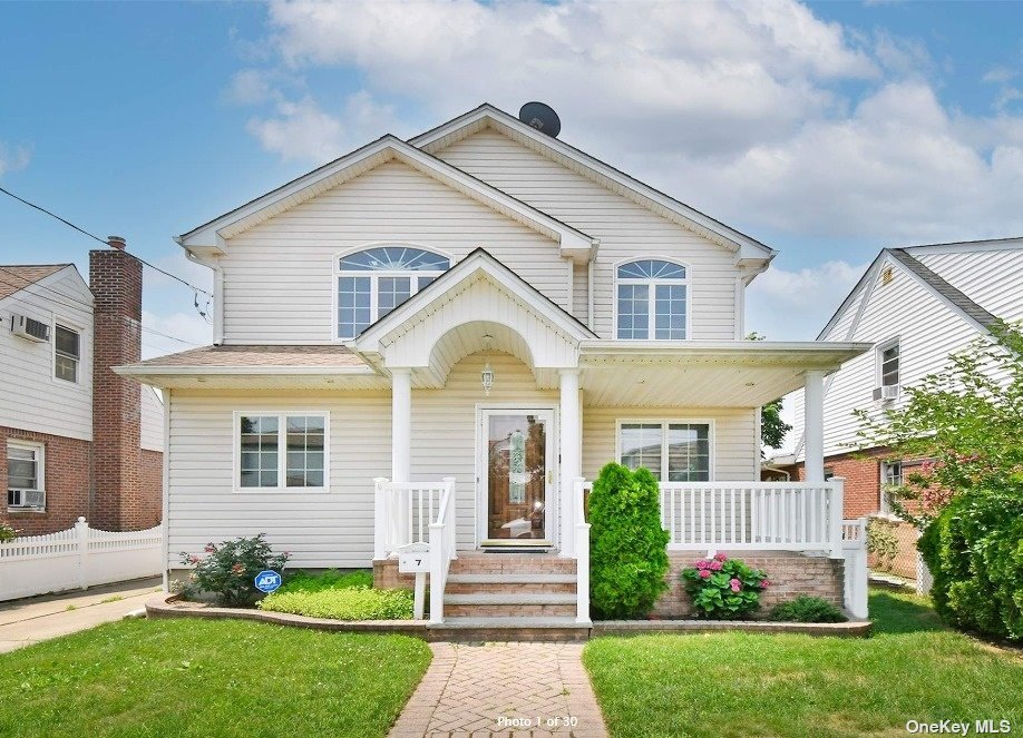 a front view of a house with a garden and plants