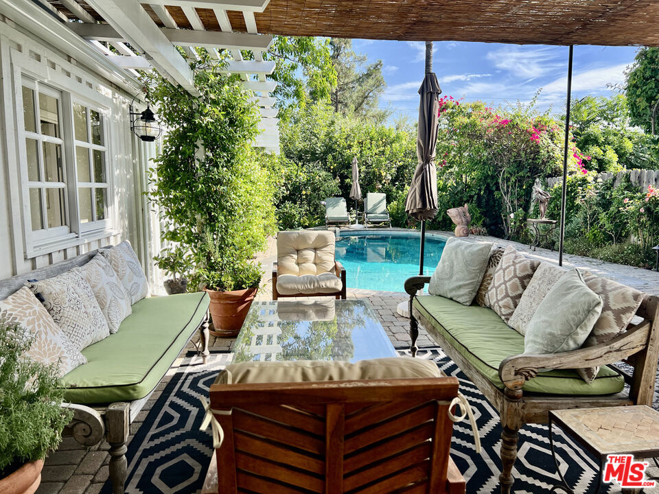 a view of a patio with couches table and chairs and potted plants