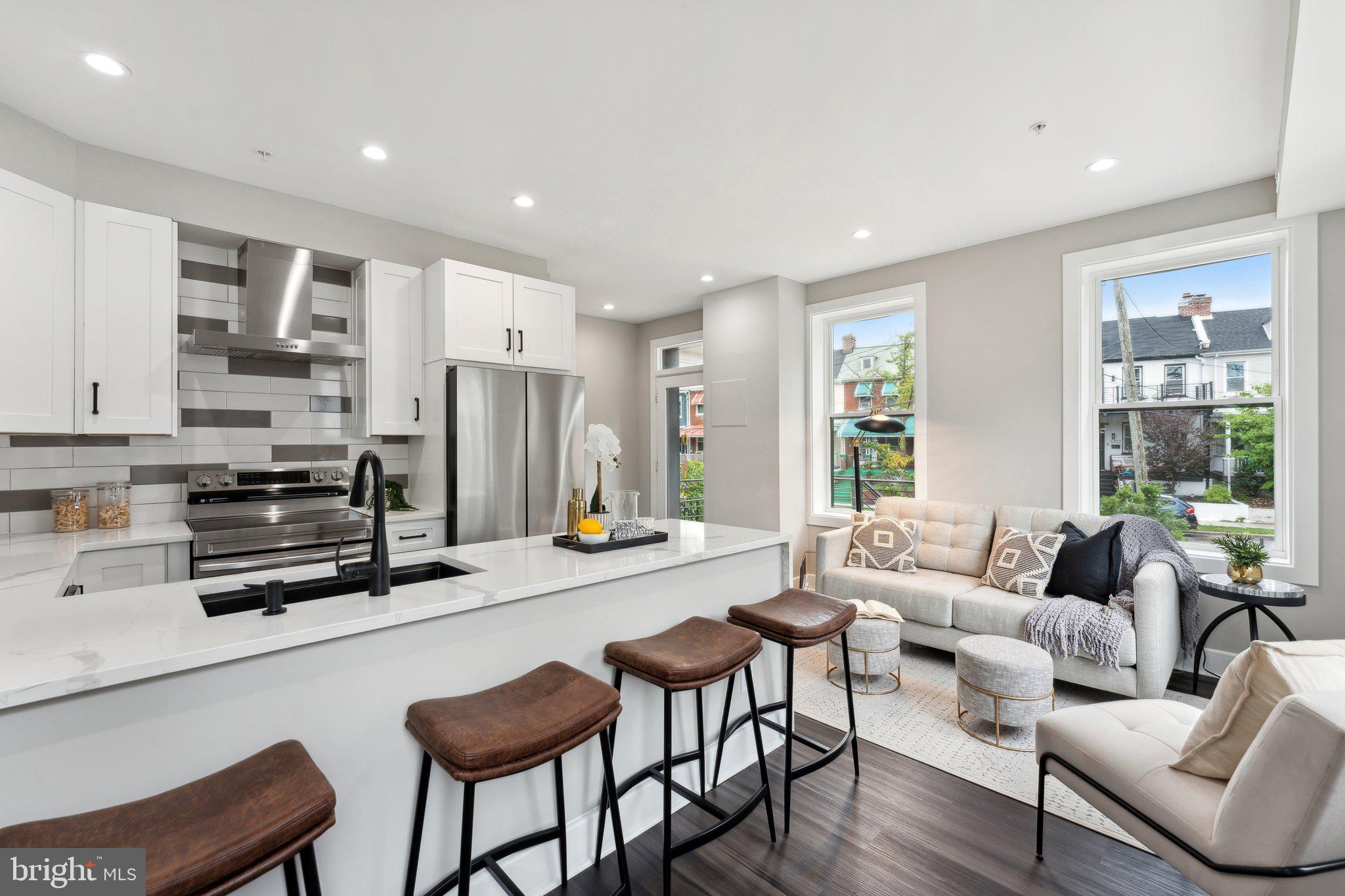 a living room with stainless steel appliances furniture a dining table and chairs