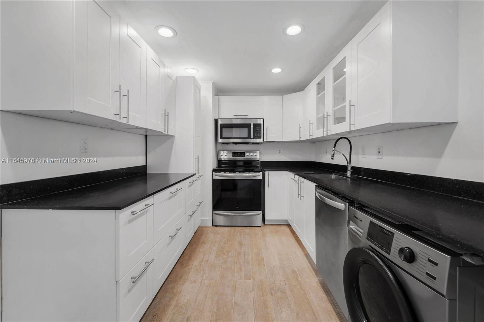 a kitchen with kitchen island granite countertop a sink and steel appliances