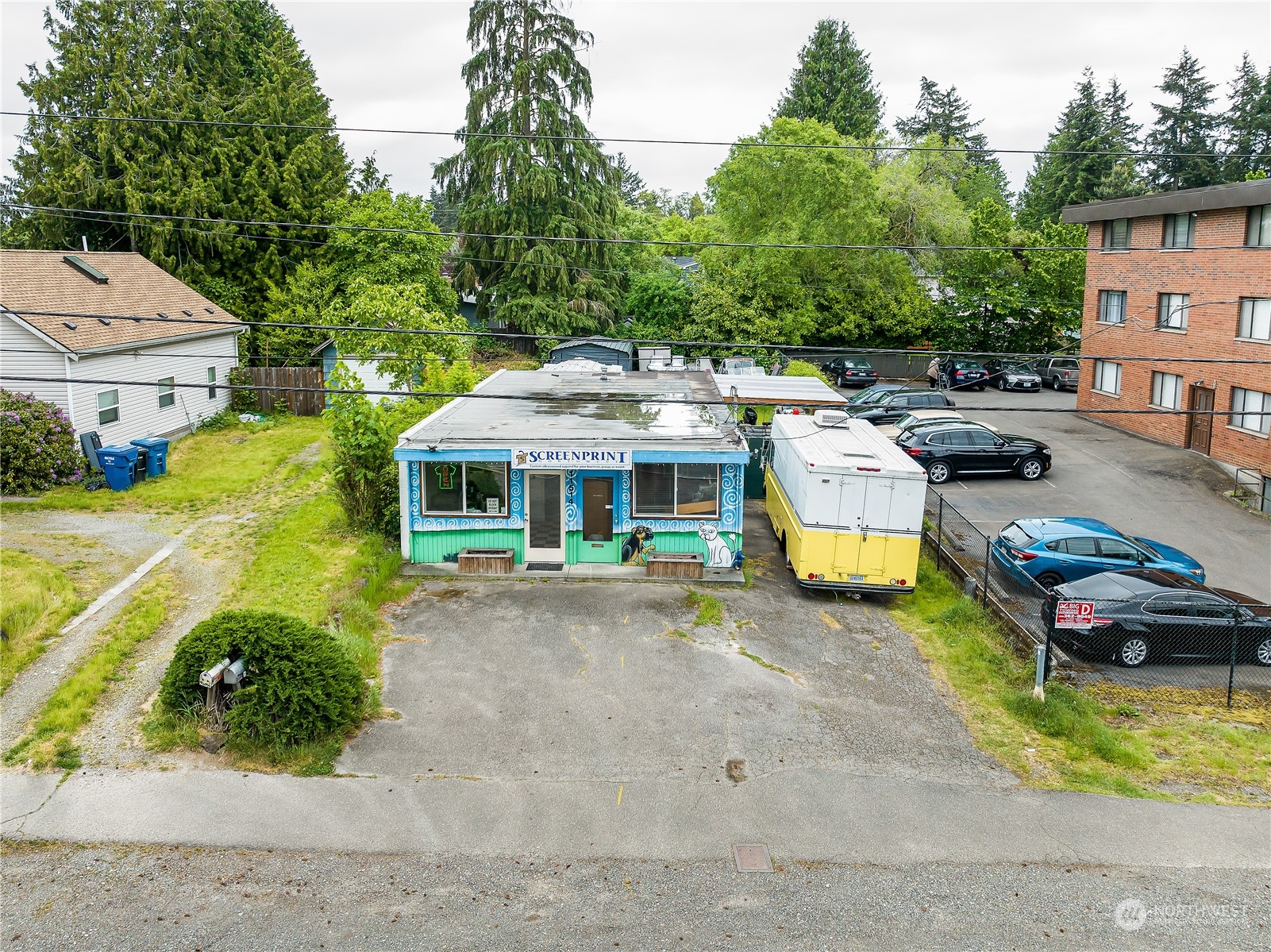 an aerial view of a house with swimming pool and large trees