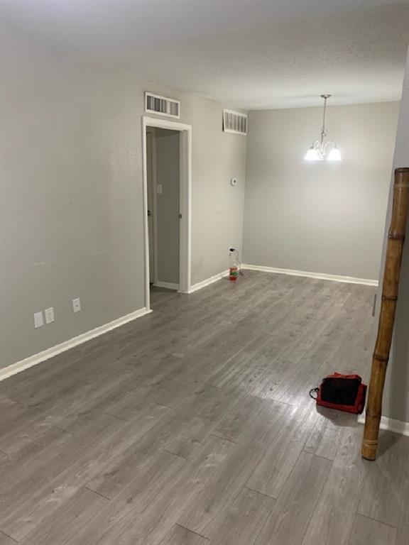 an empty room with wooden floor and bathroom