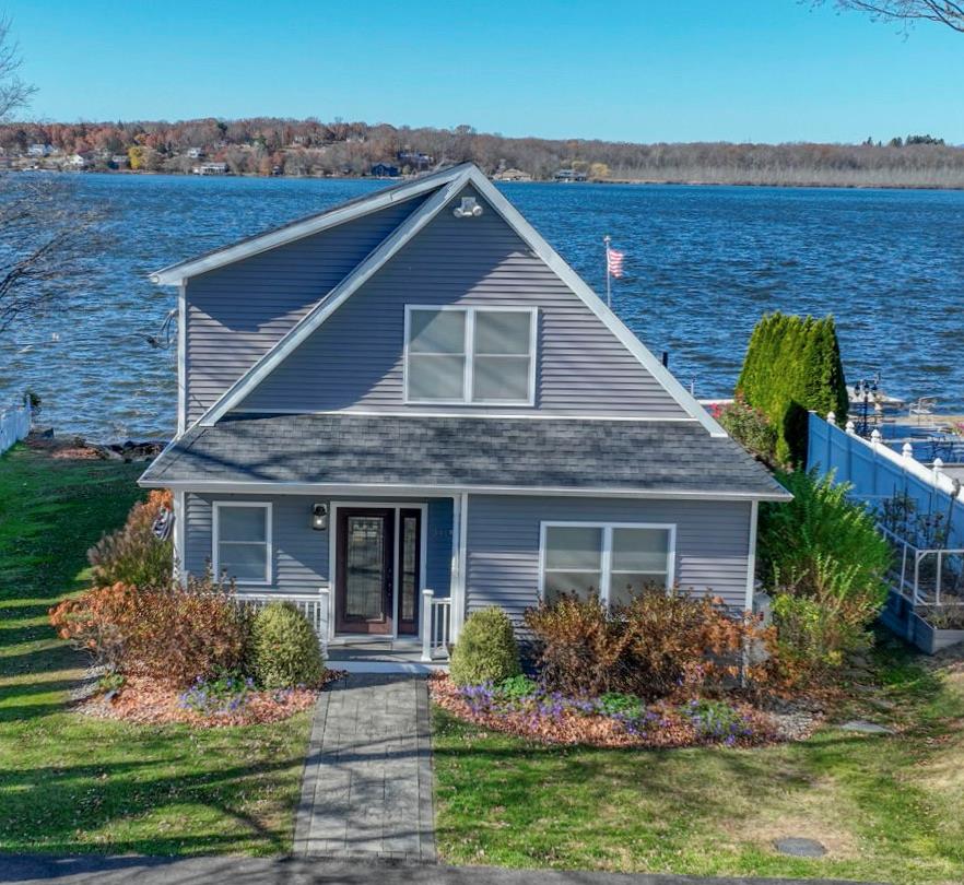 View of front of home featuring a water view and a front lawn