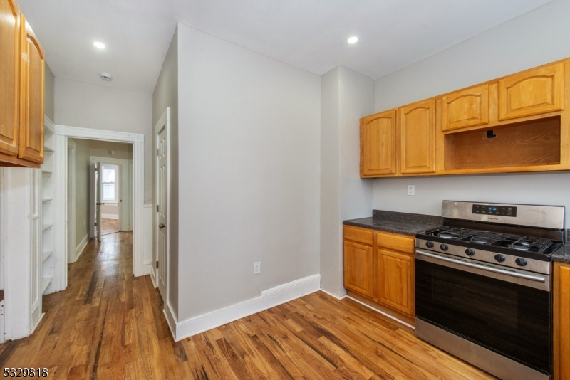 a kitchen with wooden floor and a stove top oven