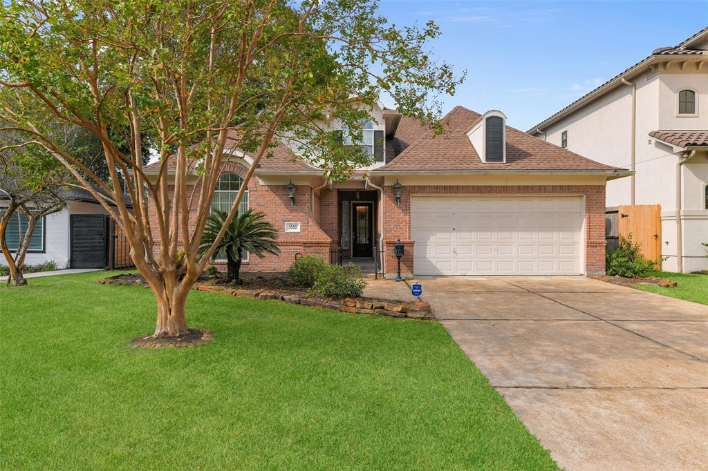 a front view of a house with a garden and yard