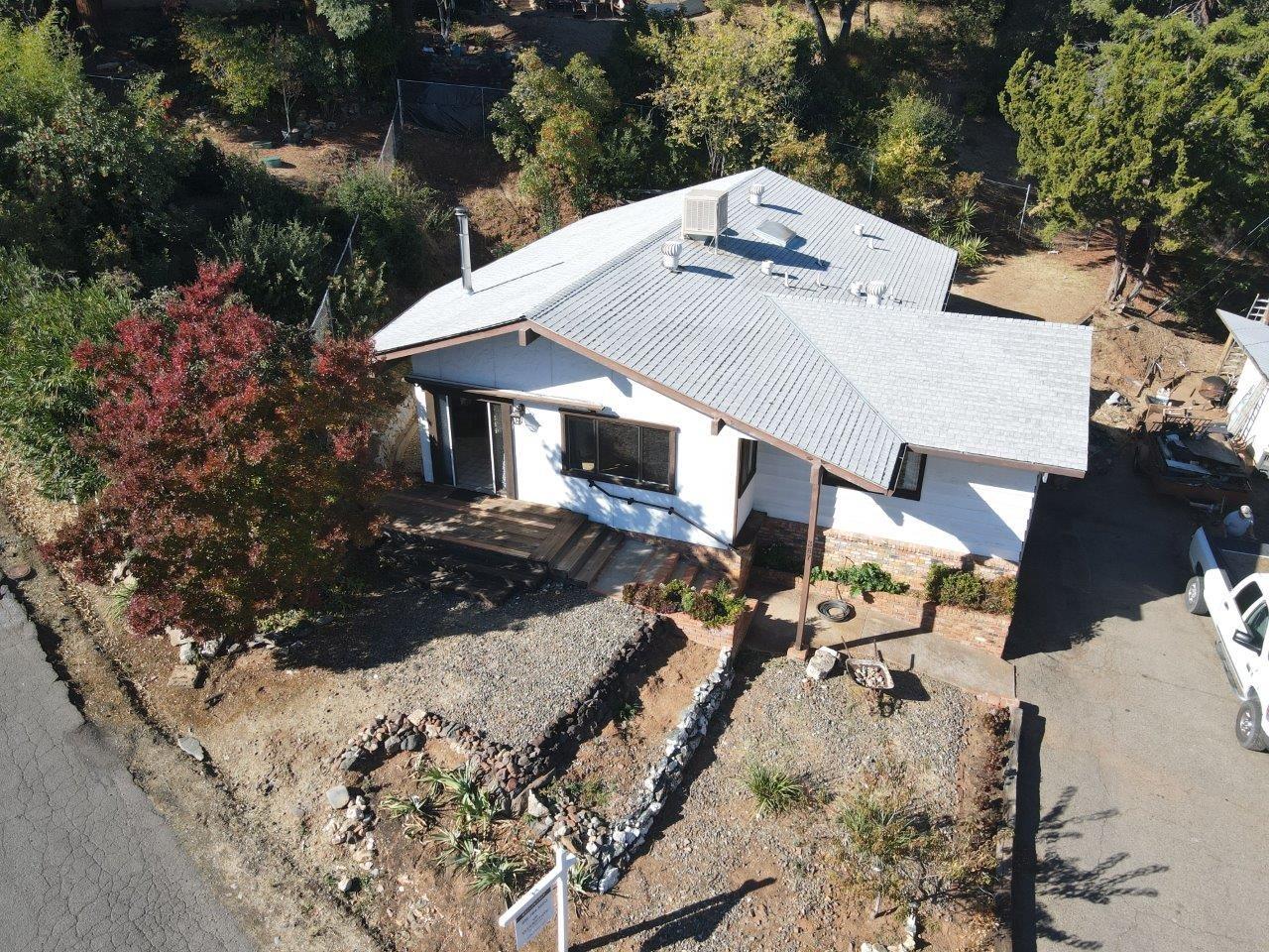 an aerial view of a house with yard and patio