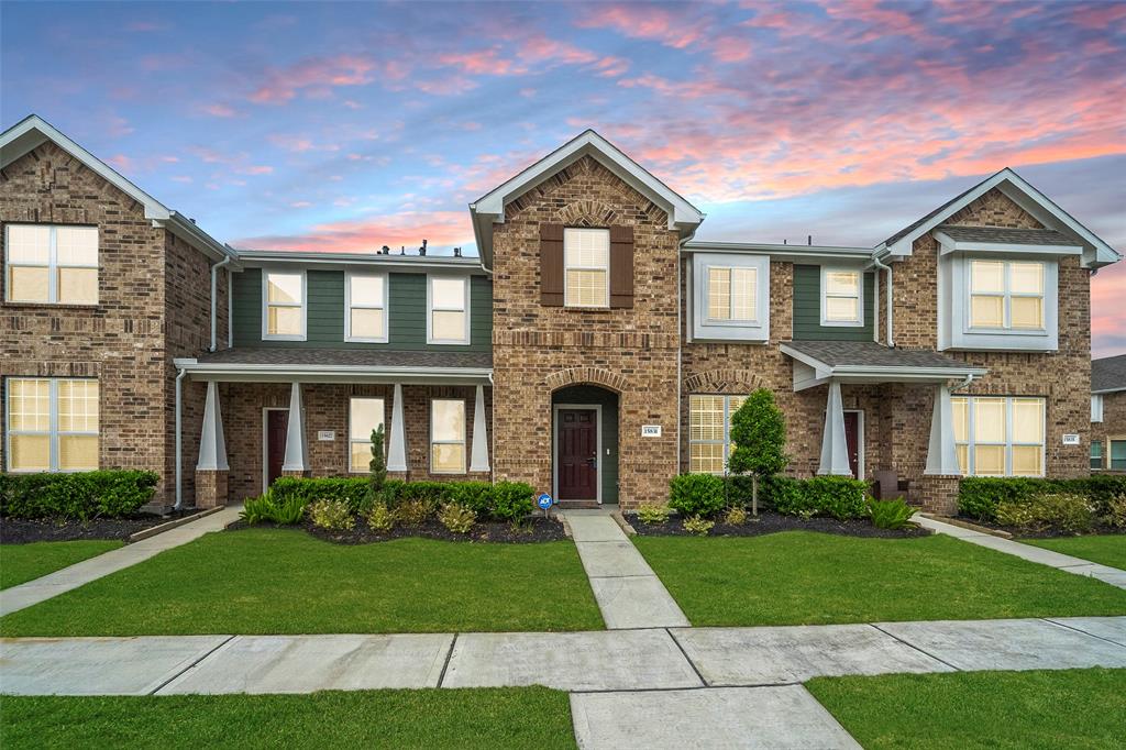 a front view of a house with a yard and outdoor seating