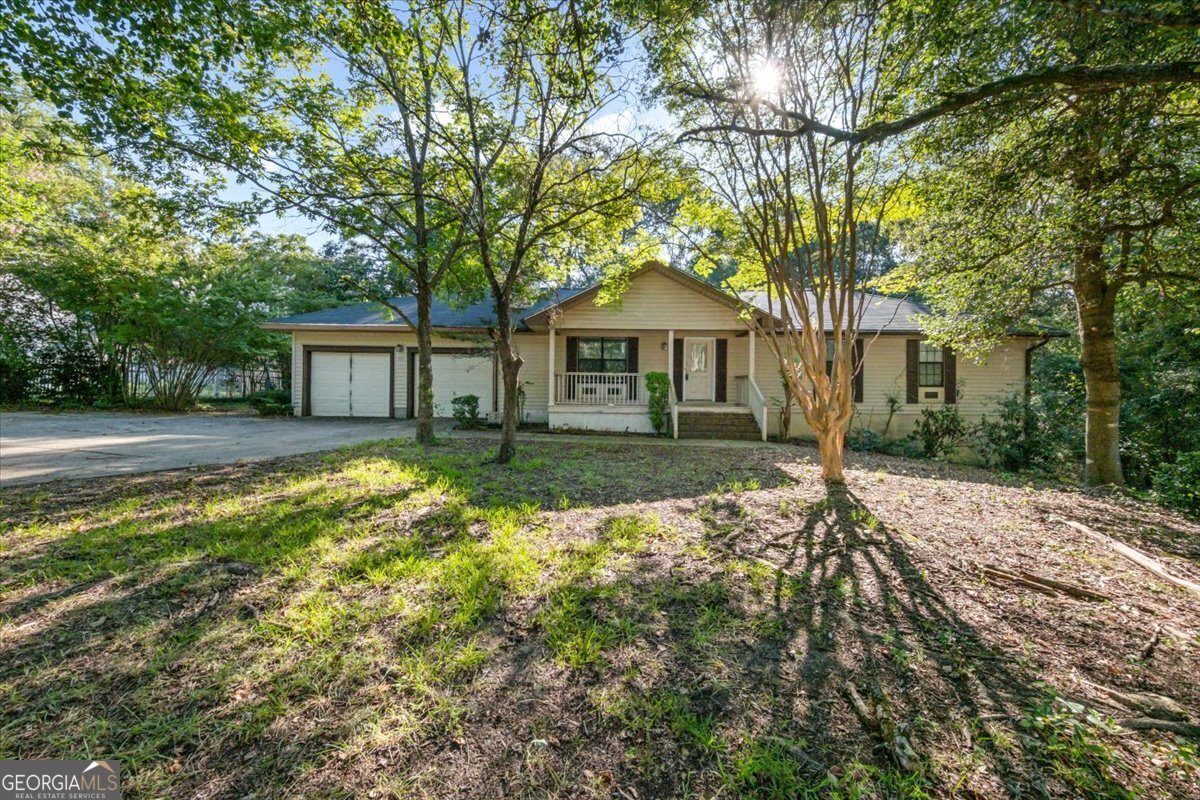 a front view of a house with a yard and trees