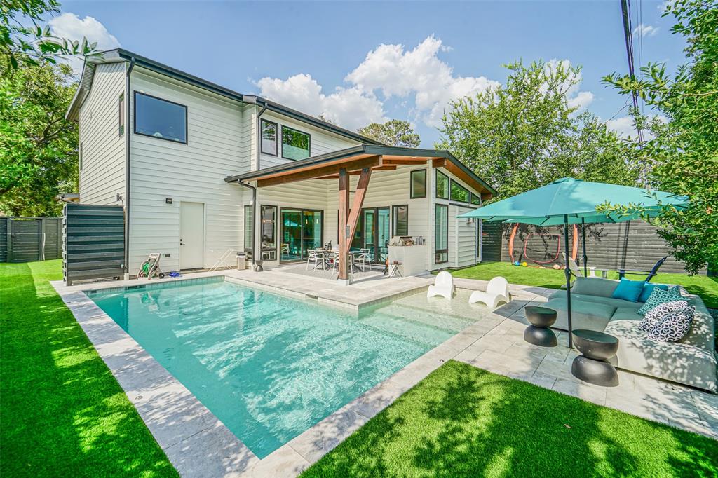 a view of a house with backyard and sitting area