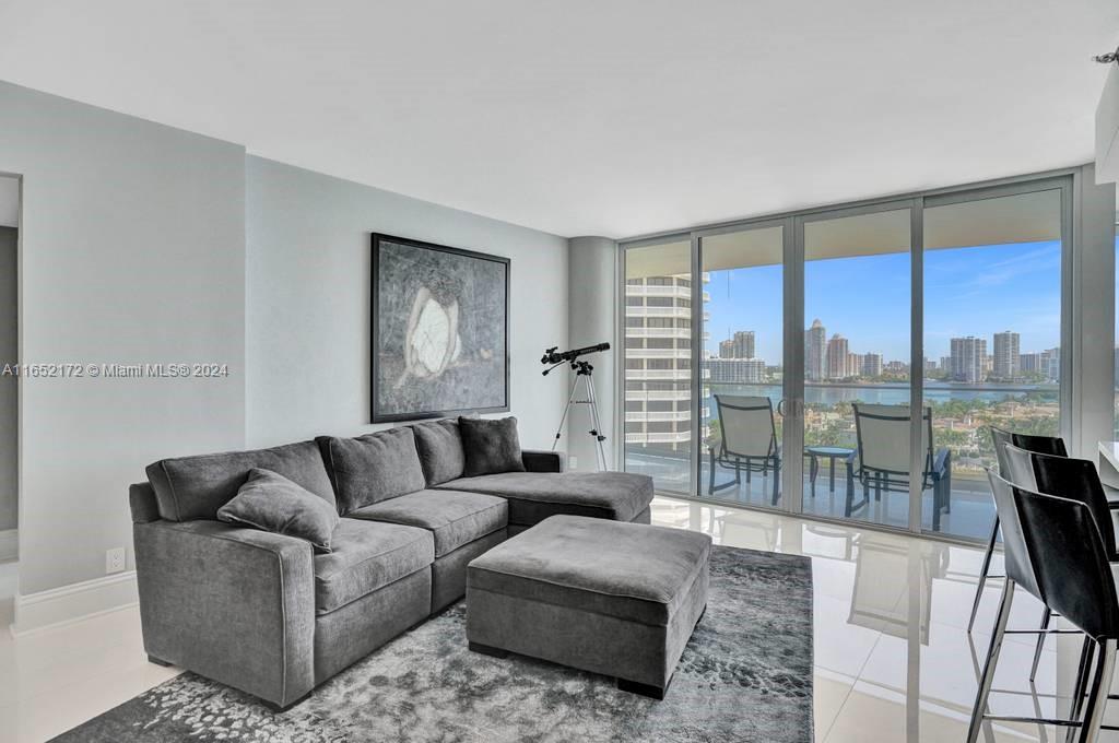 a living room with furniture and a floor to ceiling window