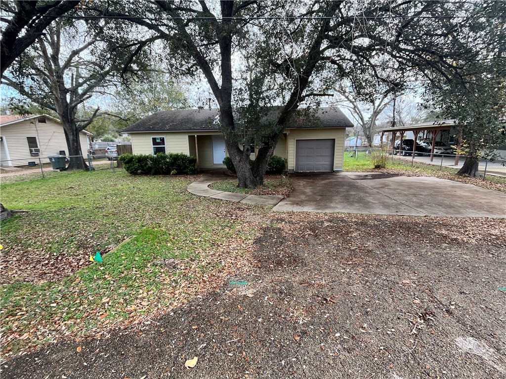 Single story home with a front yard and a garage