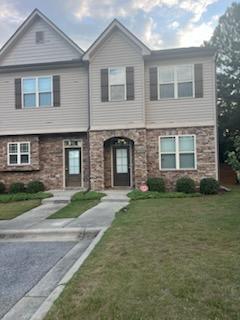 front view of a brick house with a yard