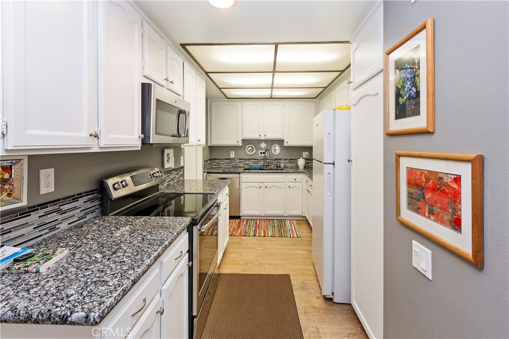 a kitchen with stainless steel appliances granite countertop a stove a sink and a microwave