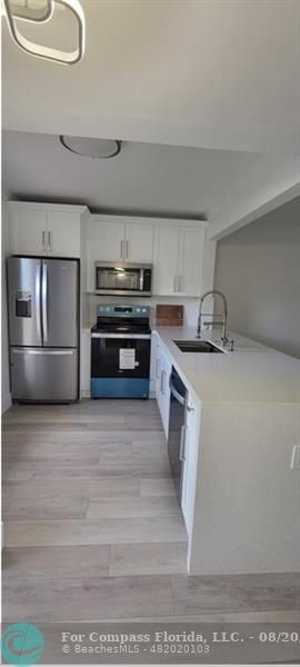 a kitchen with stainless steel appliances granite countertop a sink and a stove