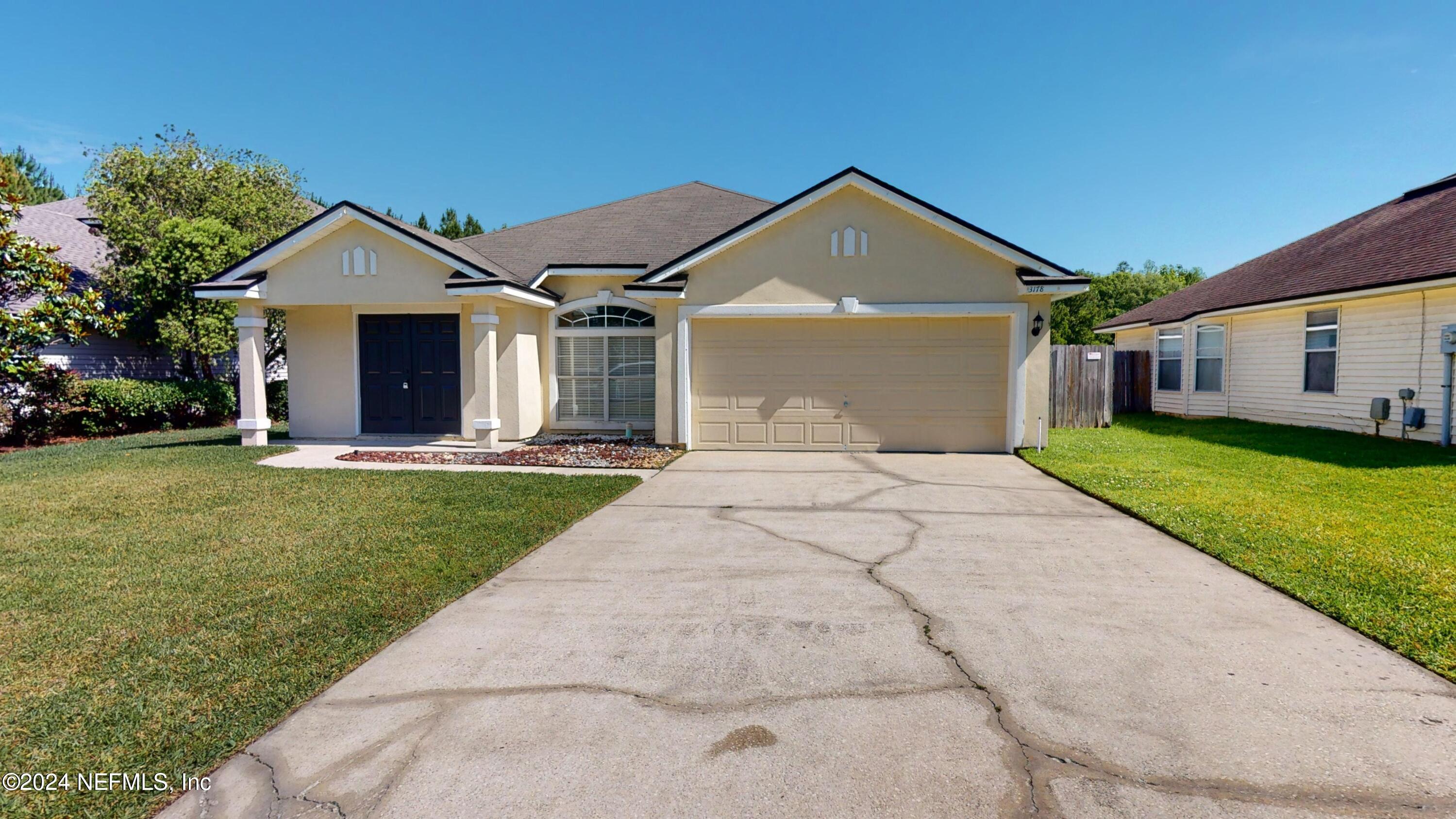 a front view of house with yard and green space