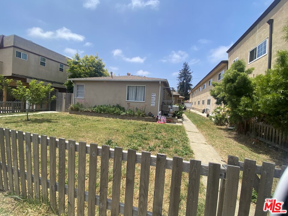 a view of a house with wooden fence