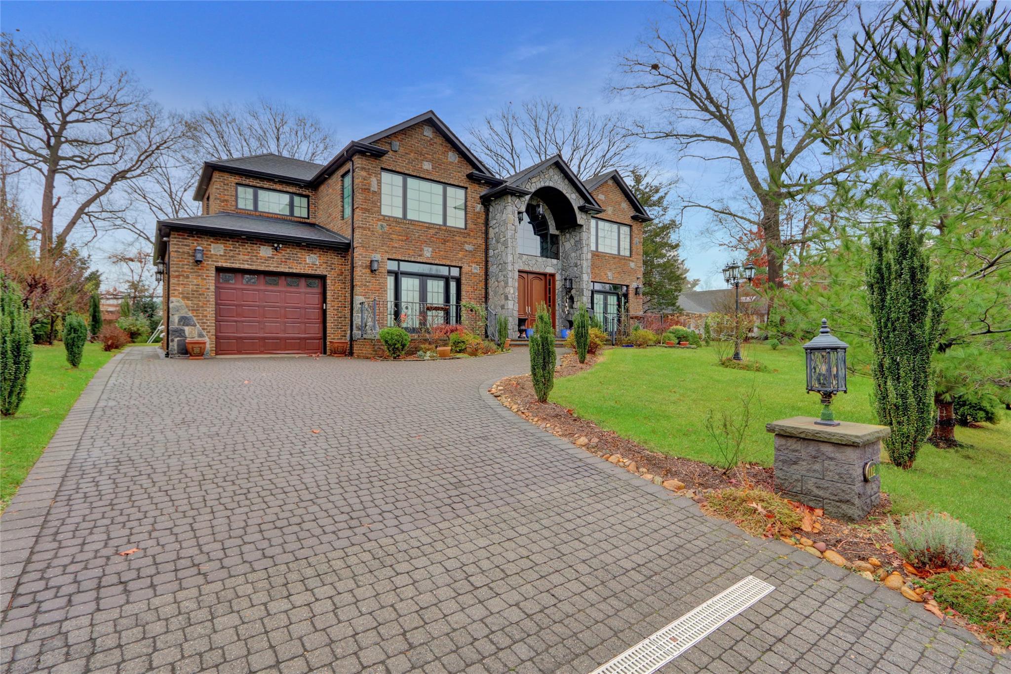 a front view of a house with a yard and trees