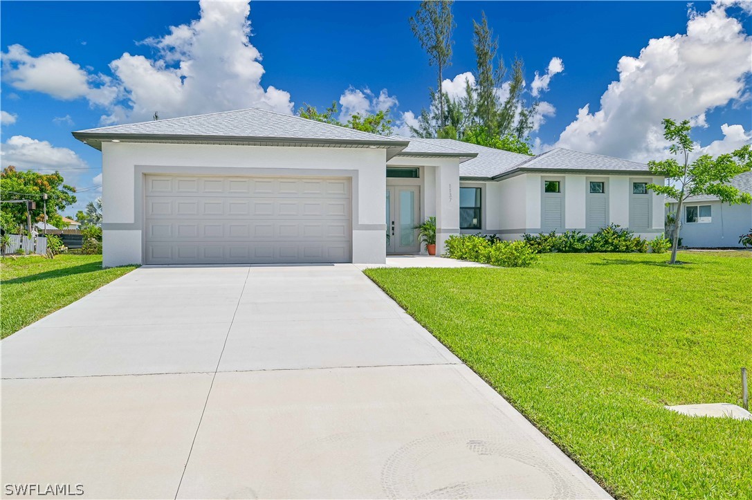 a front view of a house with a yard and garage