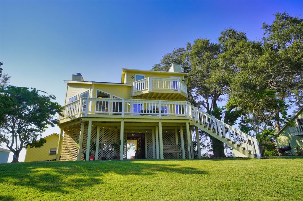 a view of a white house with a big yard and large trees