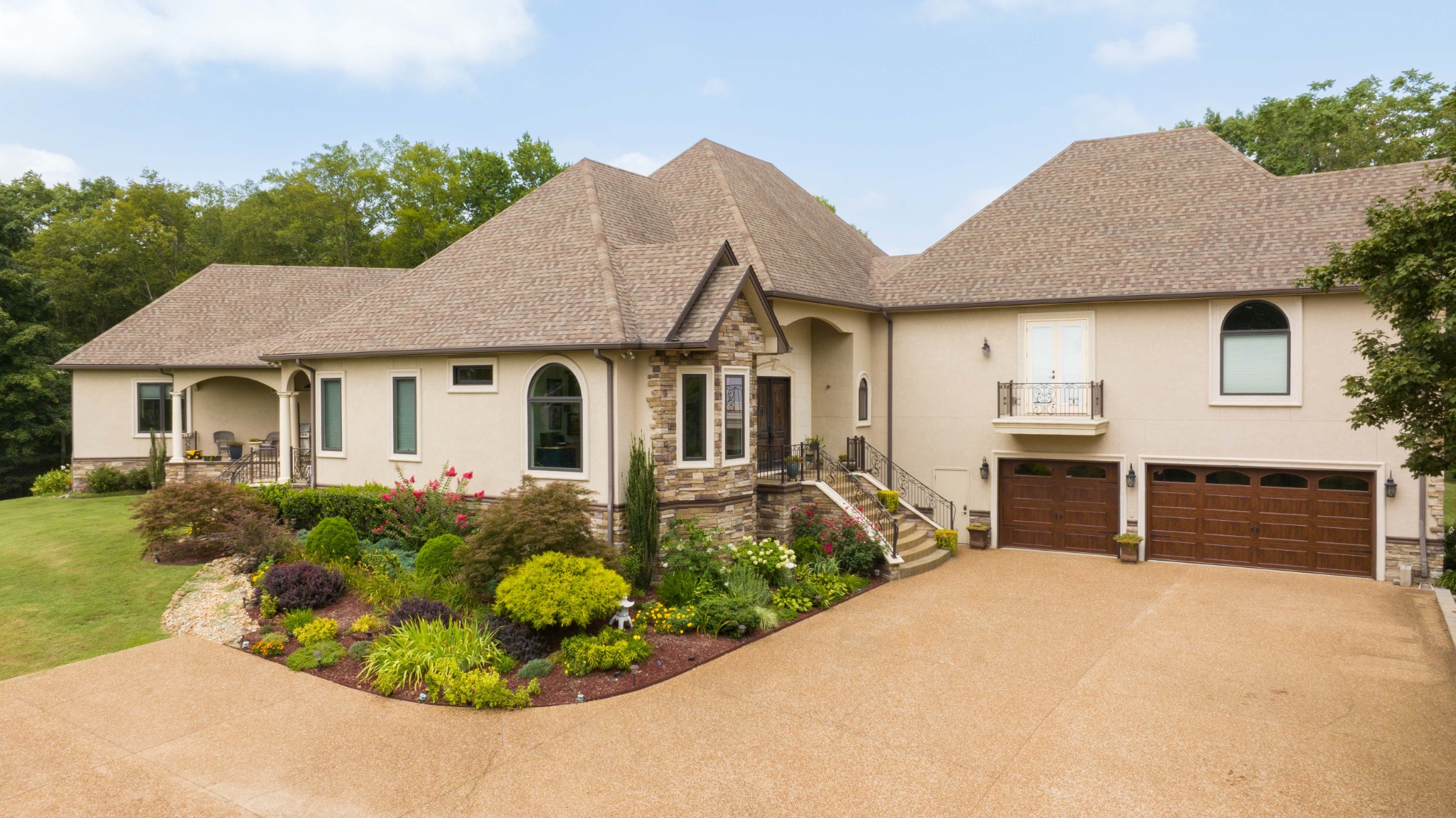 a front view of a house with a yard and potted plants