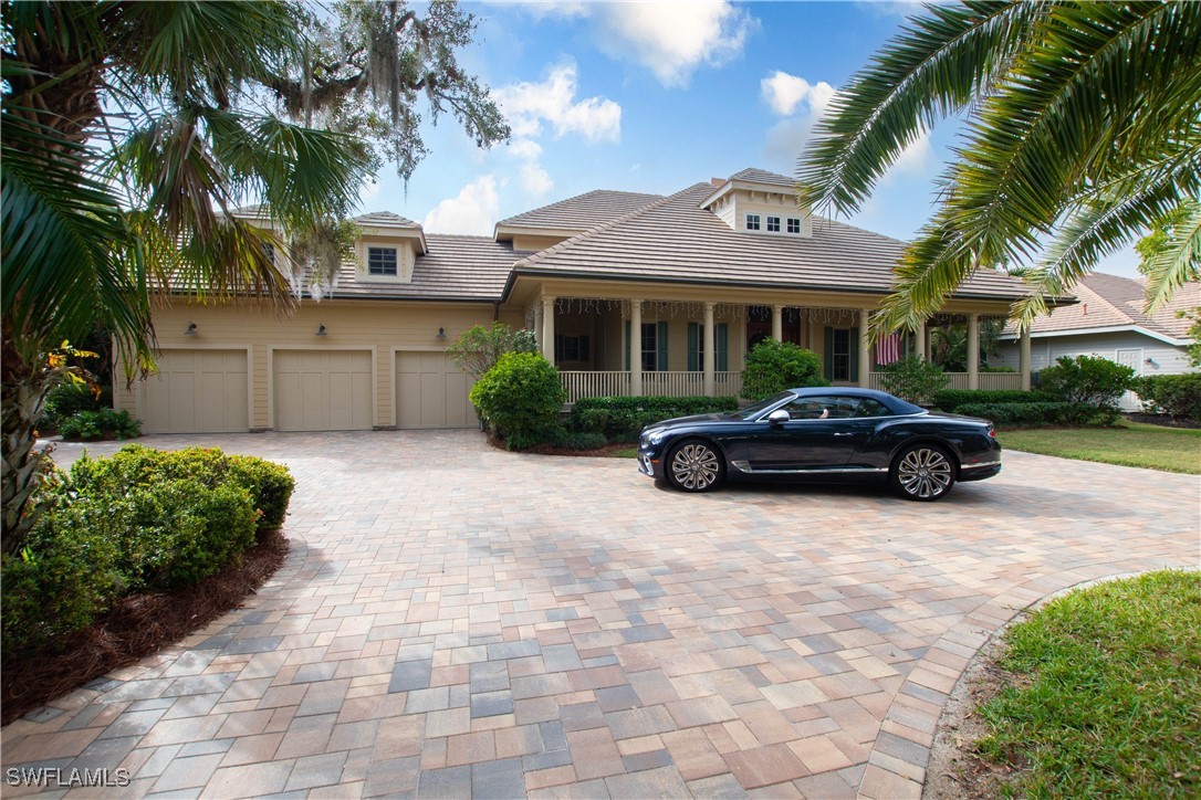 a car parked in front of a brick house with a large trees