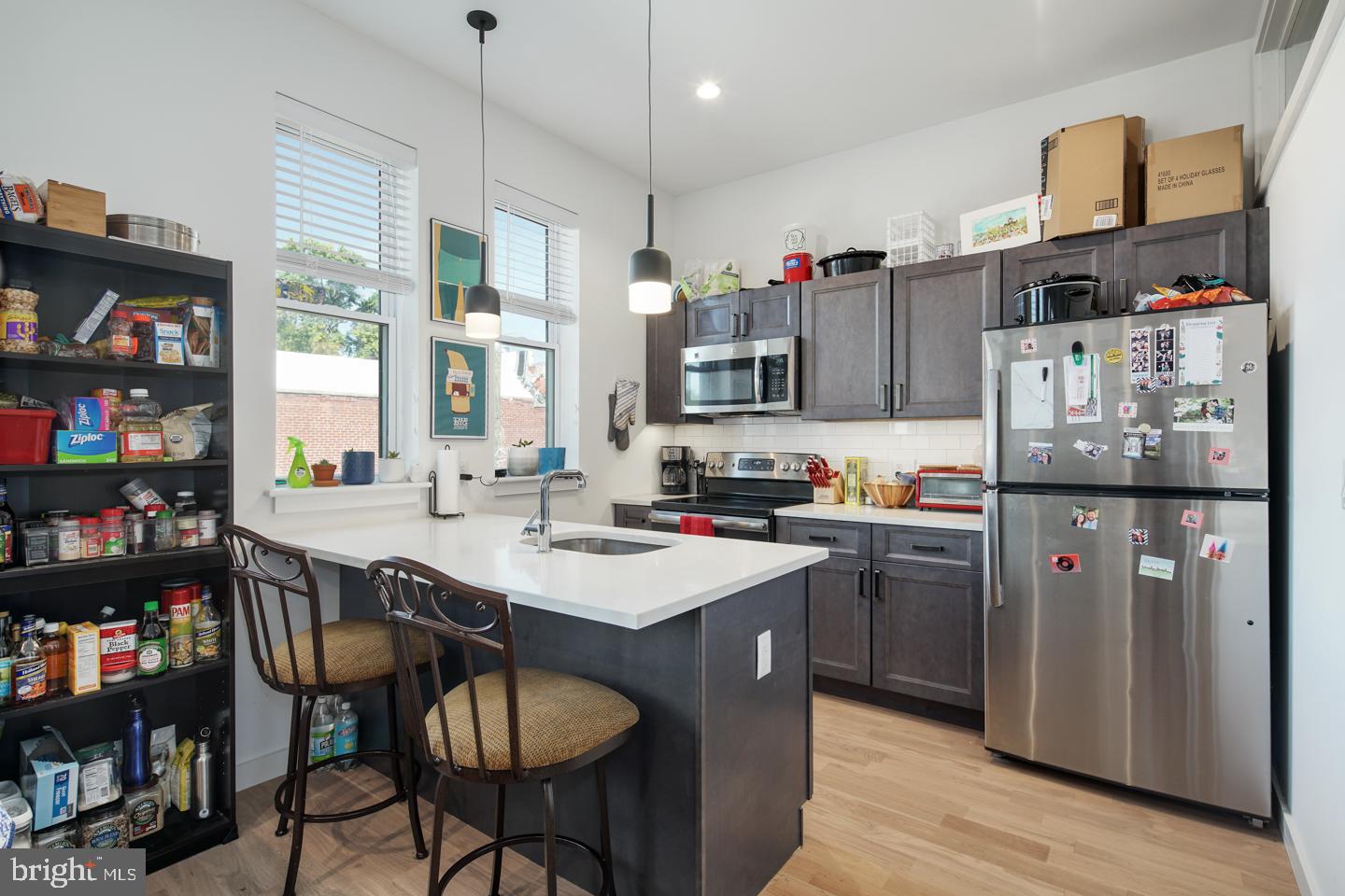 a kitchen with stainless steel appliances granite countertop a sink dishwasher and a refrigerator