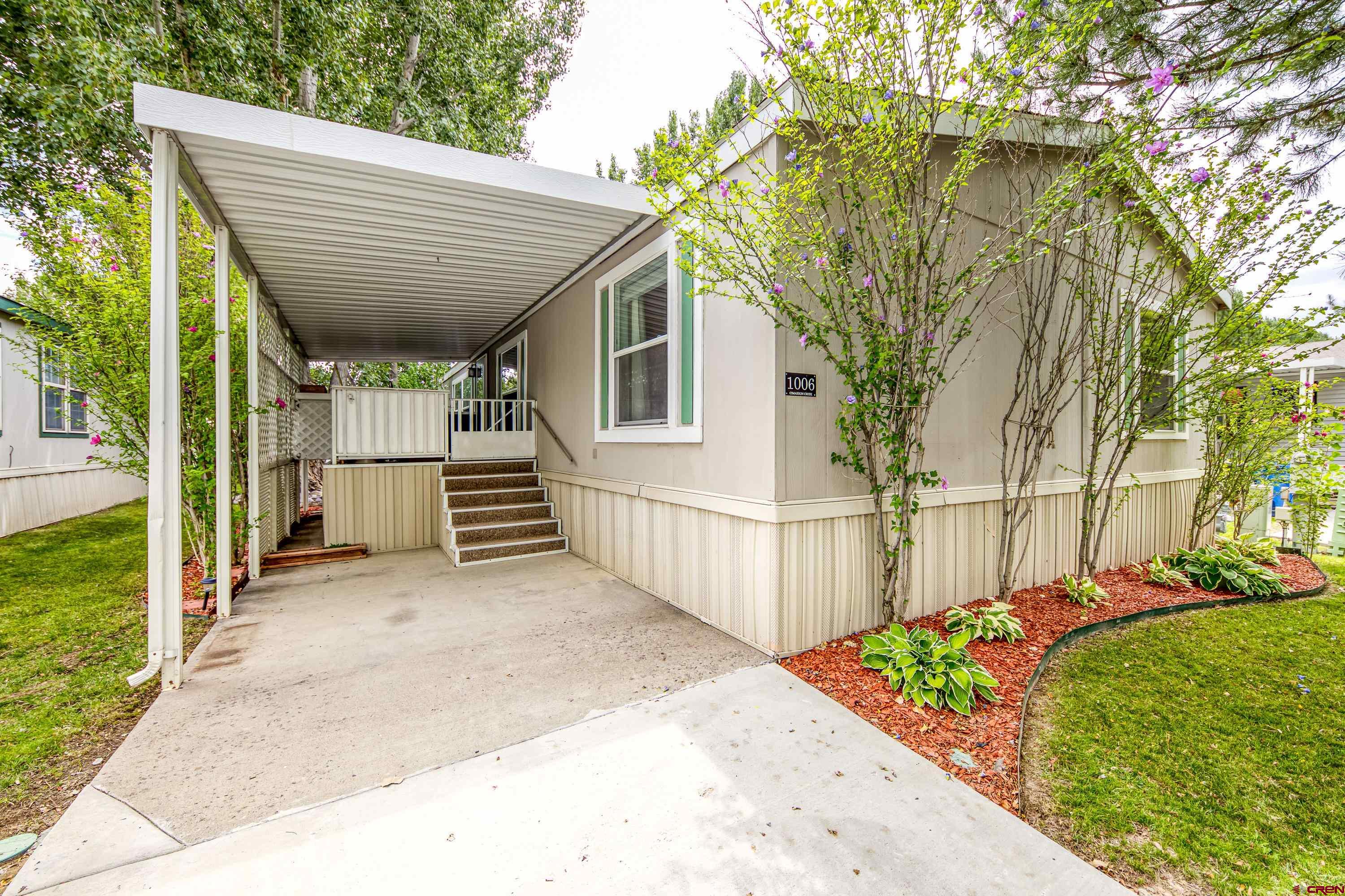 a view of a house with a wooden fence next to a yard