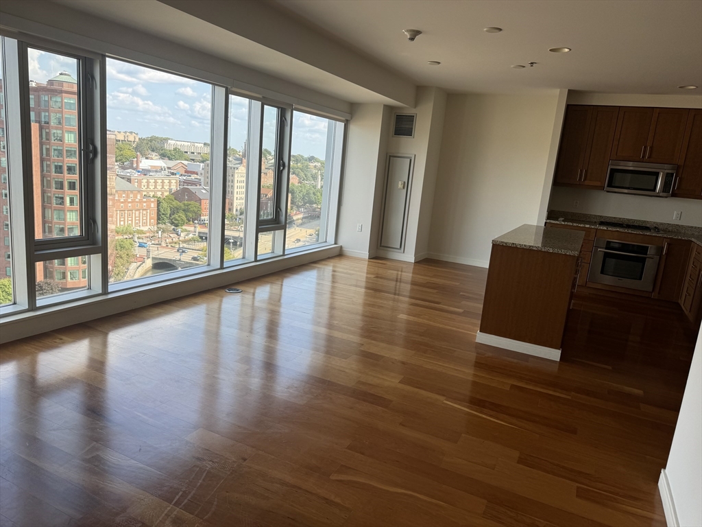 a living room with hard wood floors and a large window