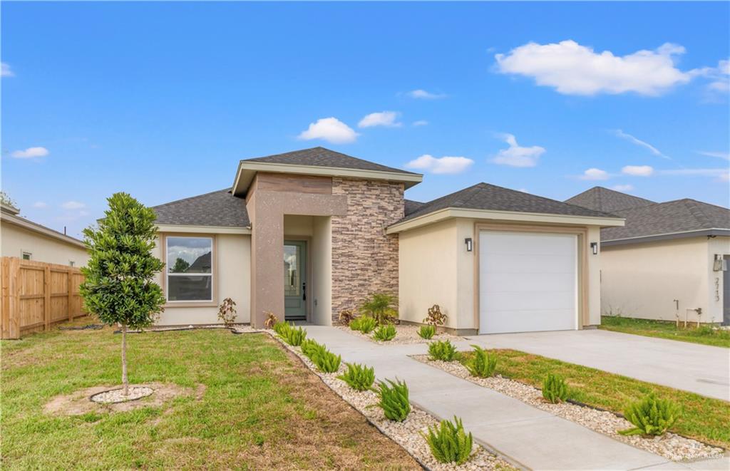 a front view of a house with a yard and garage