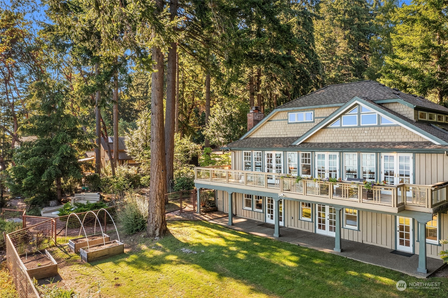 an aerial view of a house with swimming pool and large trees