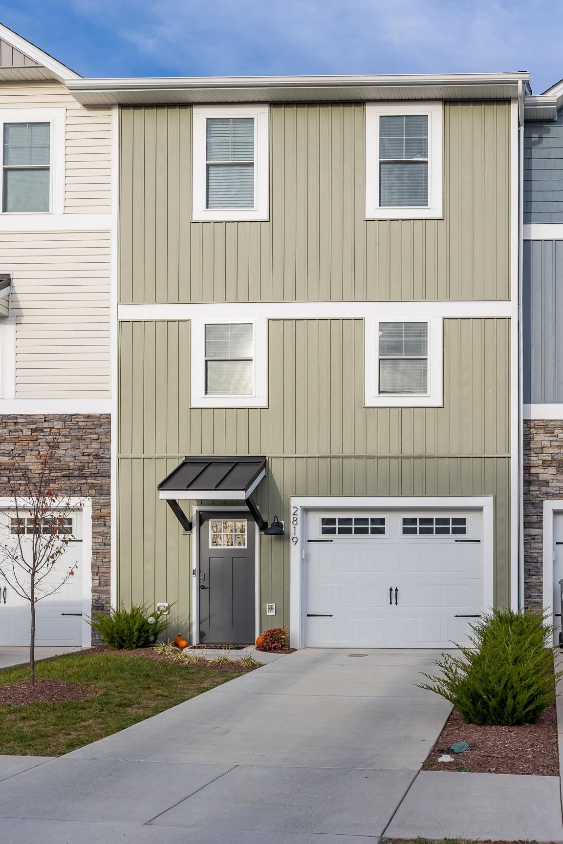 a view of a house with a yard and a large parking space