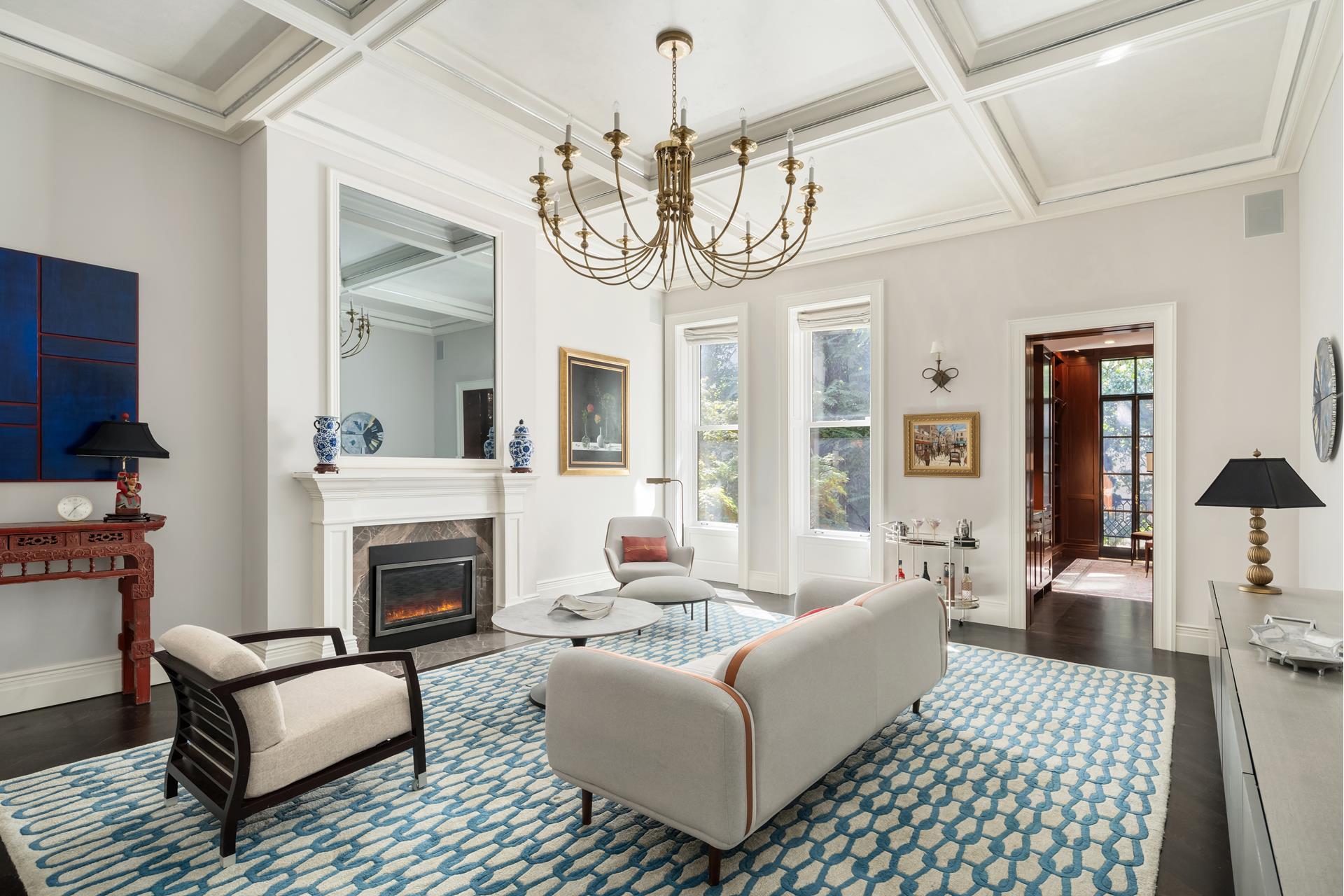 a living room with furniture a chandelier and a fireplace