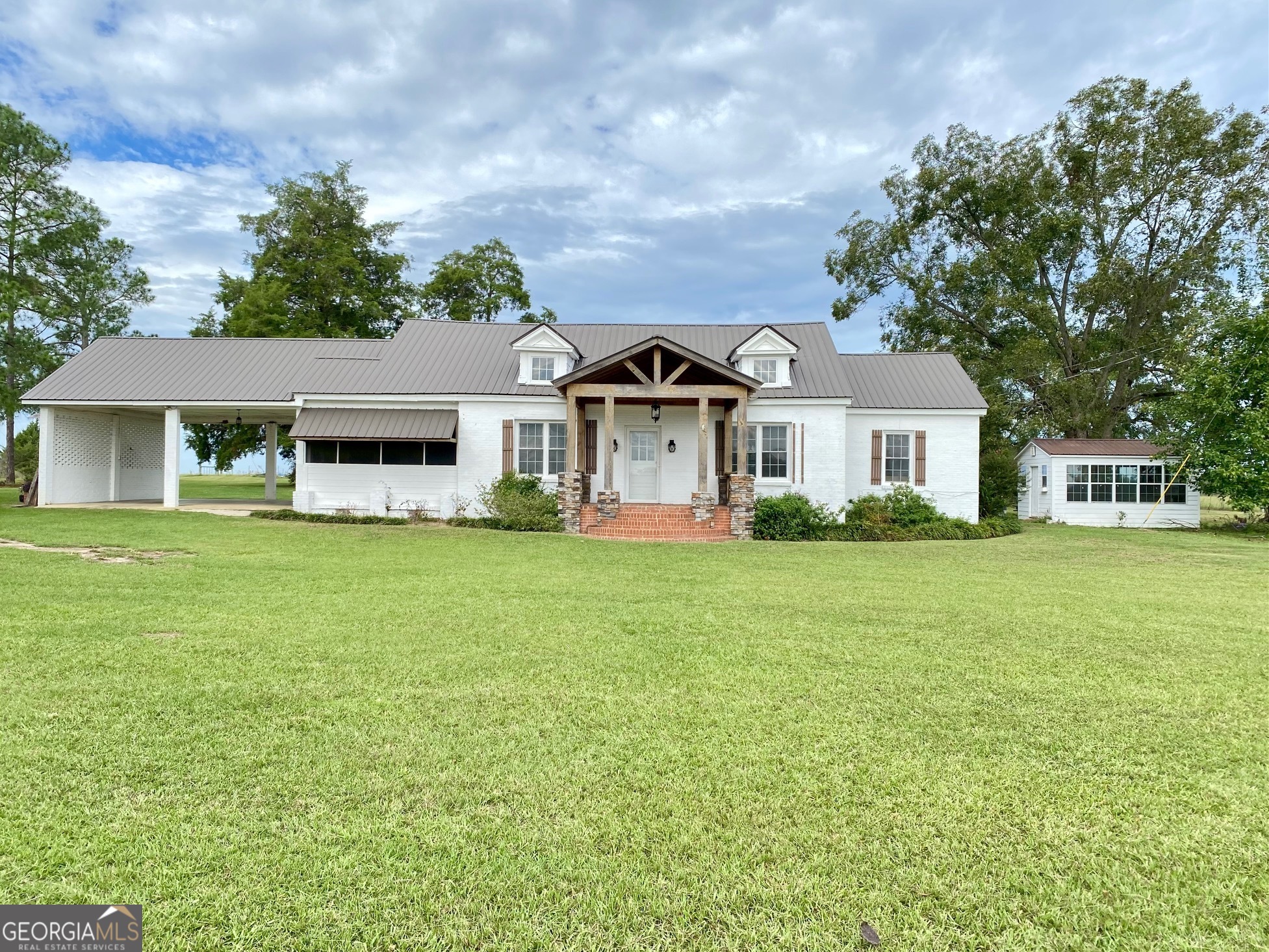 a front view of a house with a garden and yard