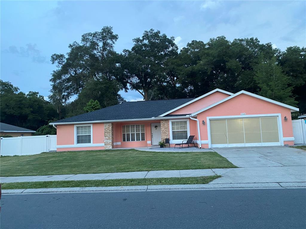 a front view of a house with a yard and trees