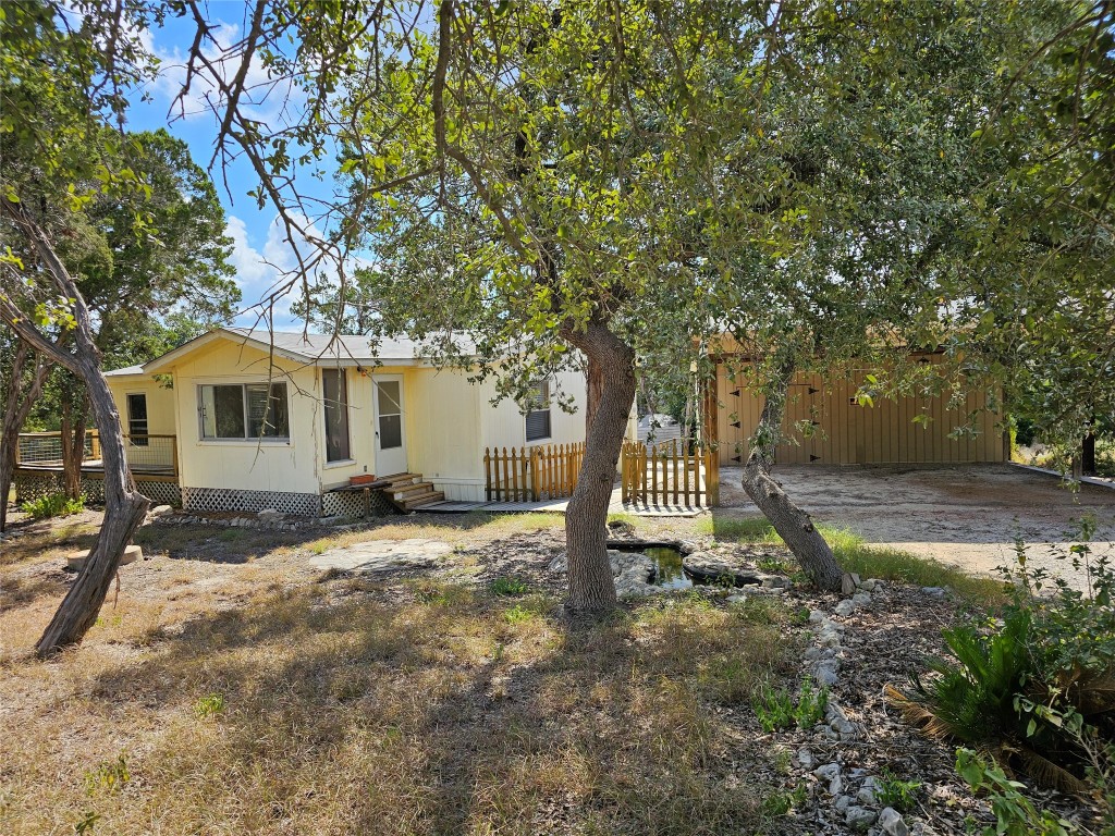 a view of a house with backyard and trees