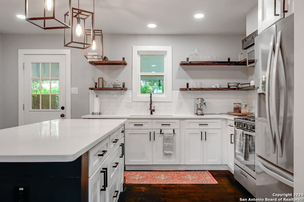 a kitchen with kitchen island granite countertop a sink stainless steel appliances and cabinets